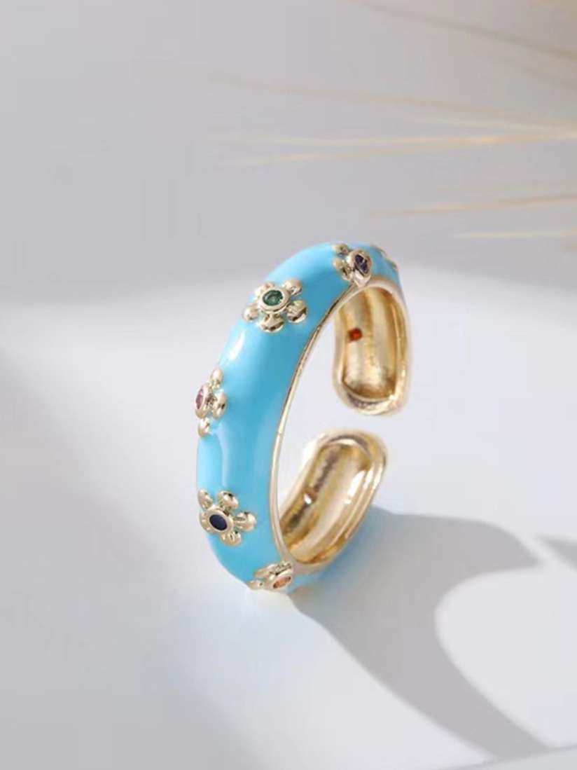 Gold and blue ring with floral designs on a light background