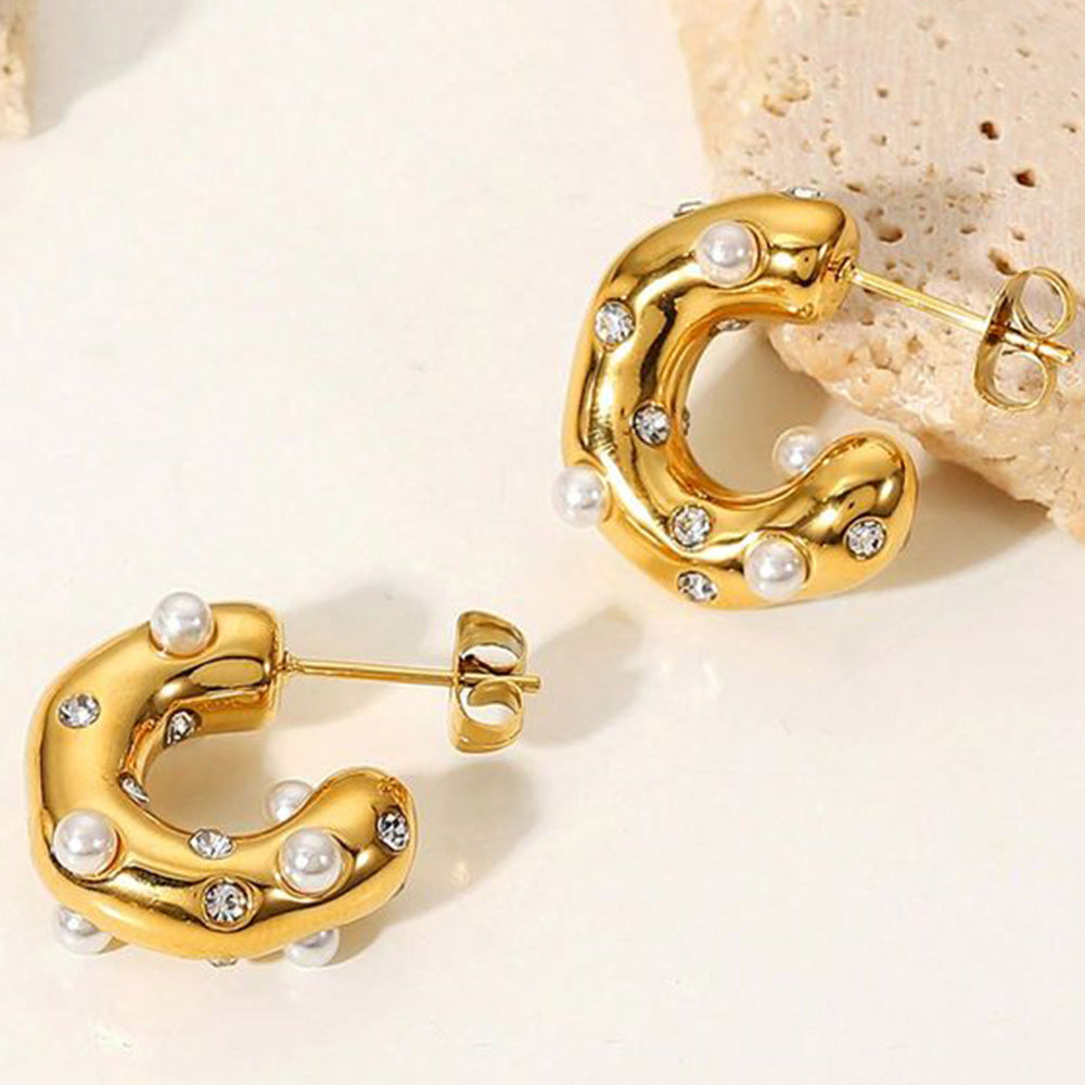 A close-up image of a pair of gold-plated hoop earrings with pearls and small sparkling stones