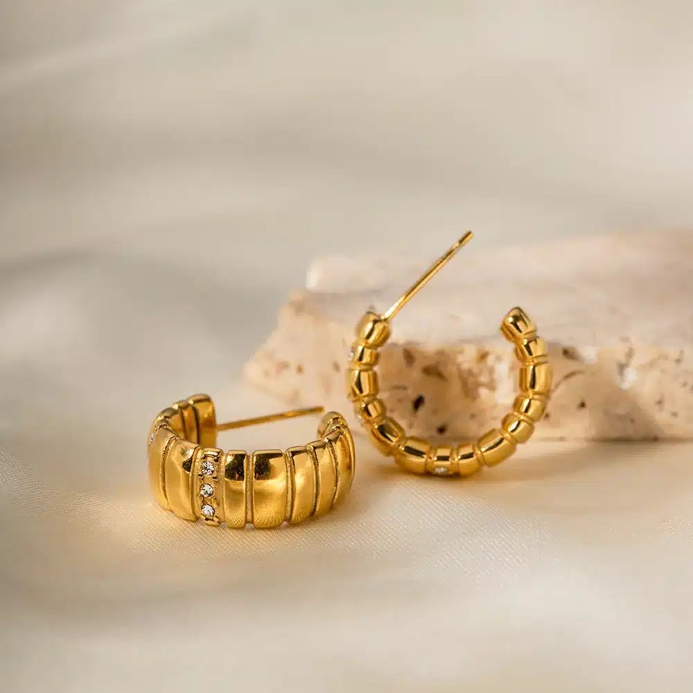 close up image of a gold plated earring with stones embellised on it