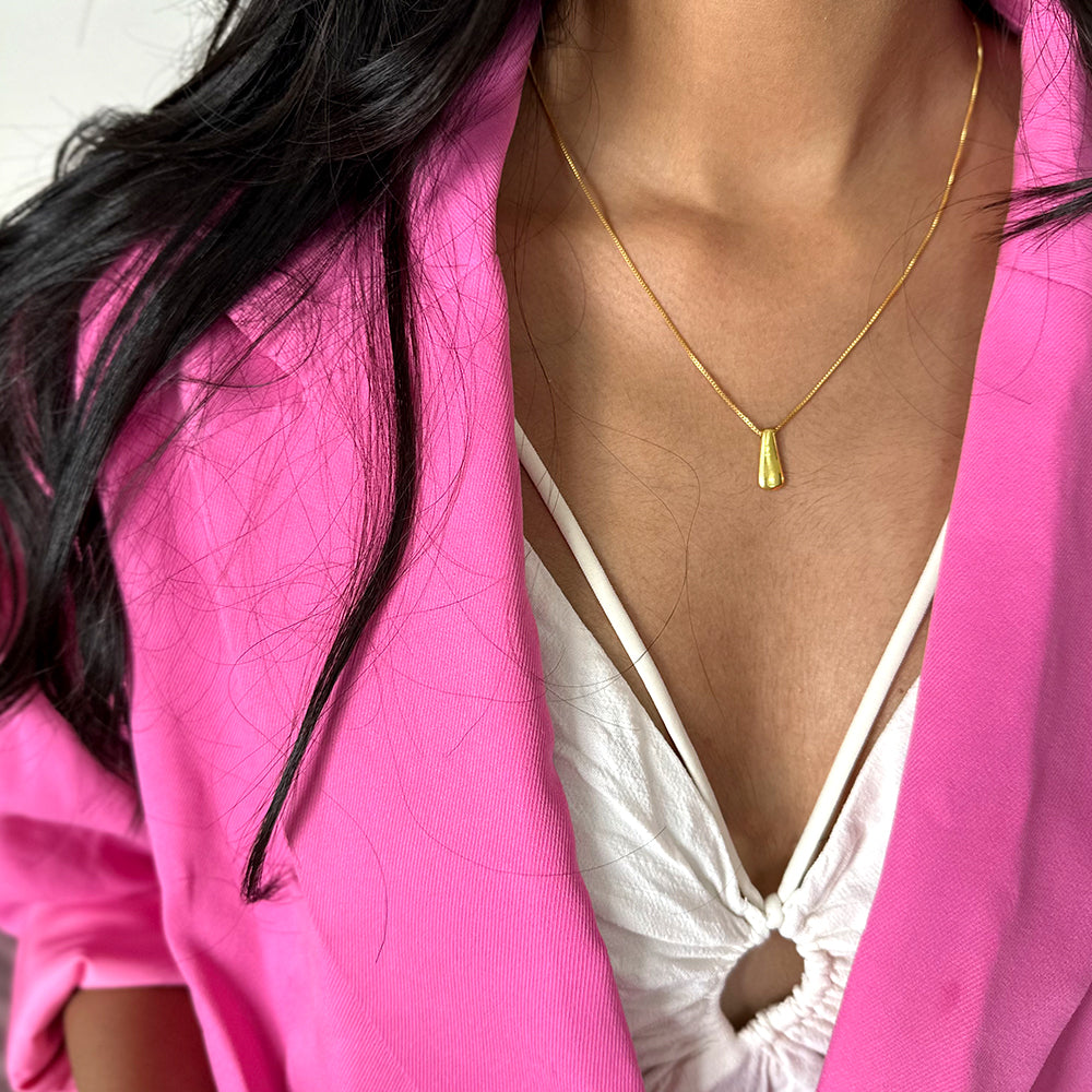 A gold-plated drop pendant necklace displayed on model