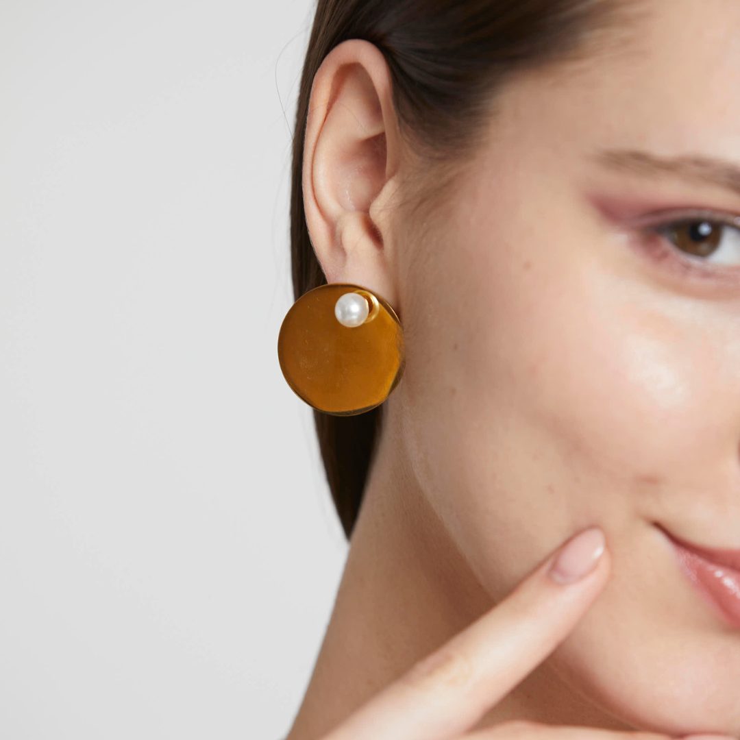gold tones stud earring with a detachable pearl stud displayed on a model ear