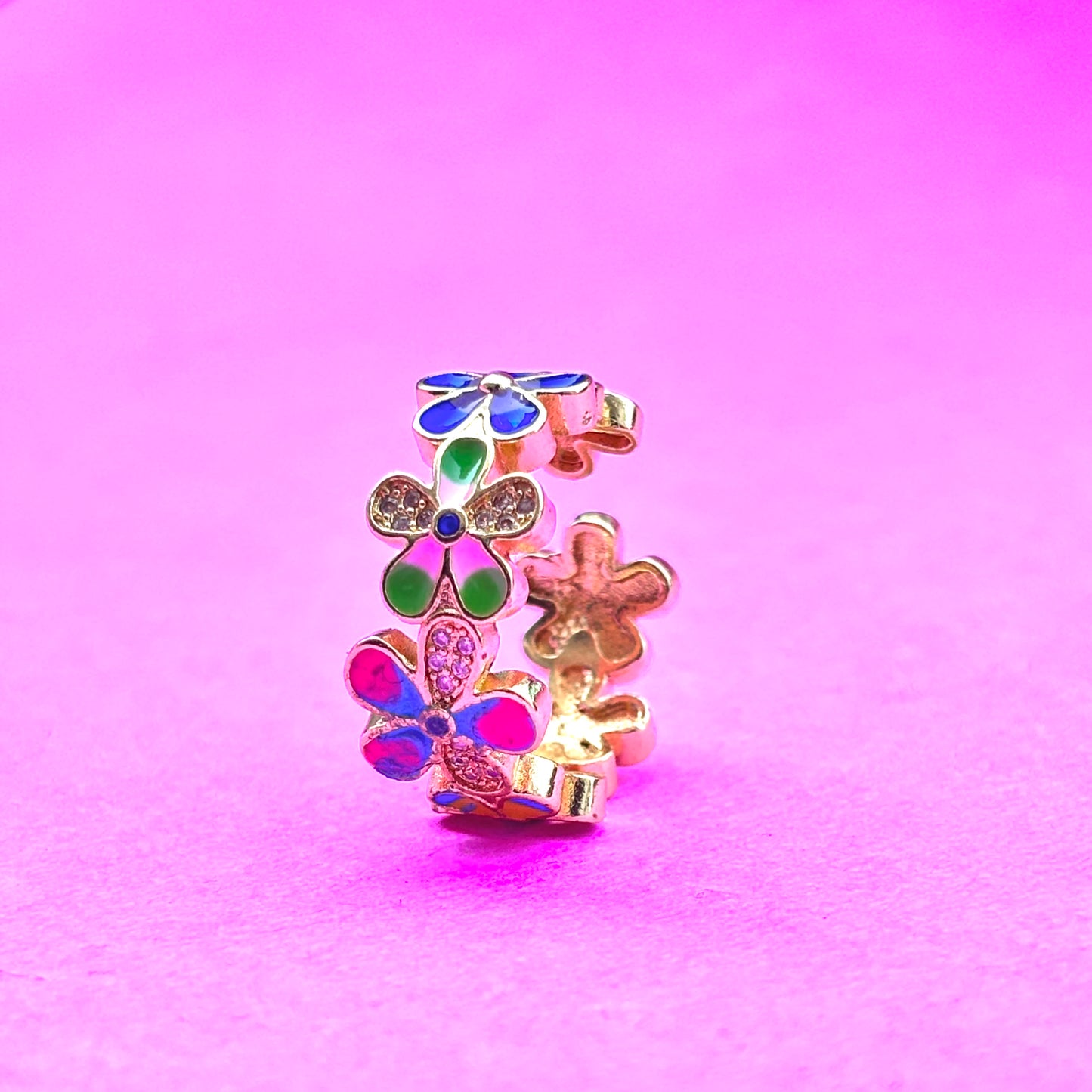 gold ring which colorful flower pattern on it with a hint of gold stones as well