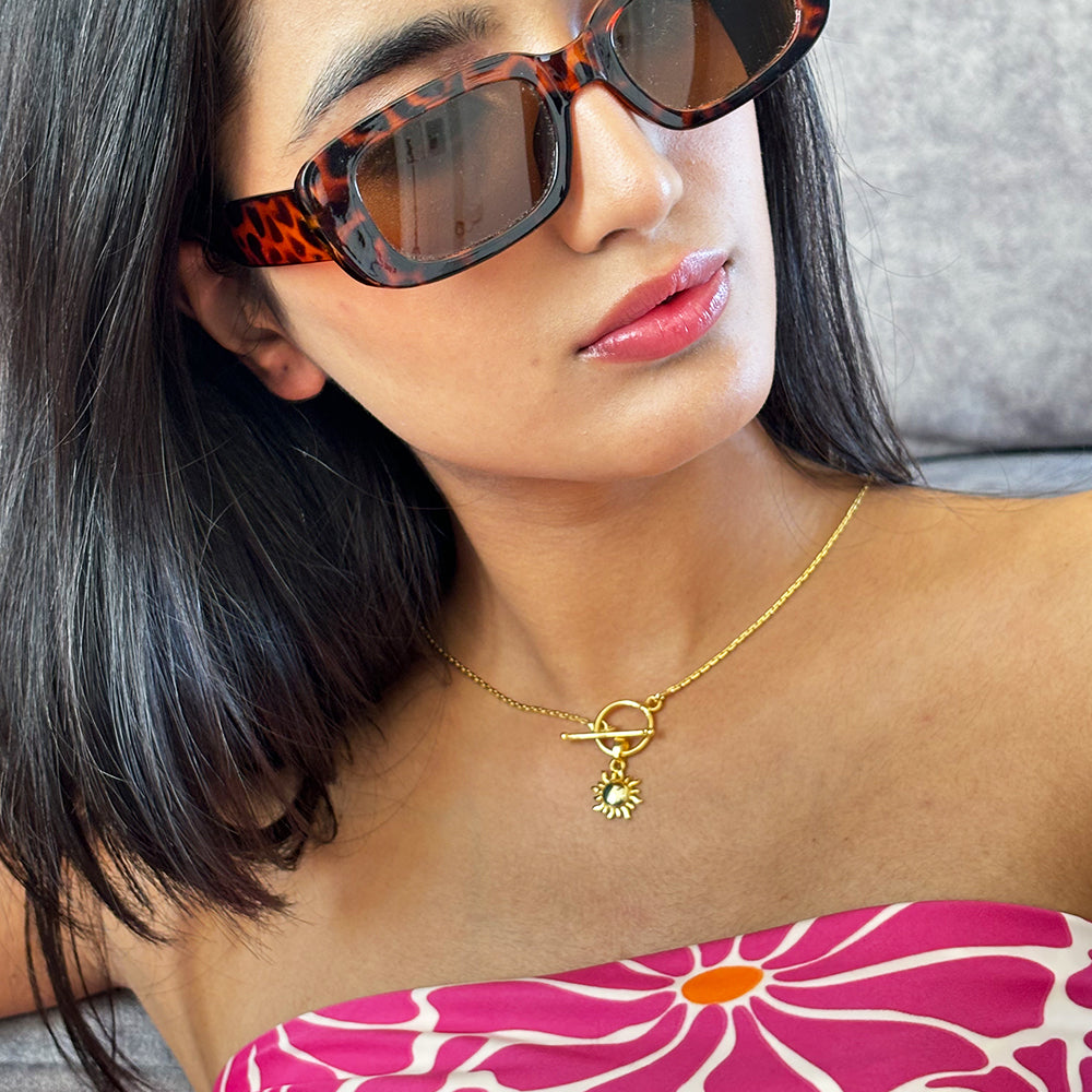 Minimalist gold plated necklace with sun charm pendant displayed on a model