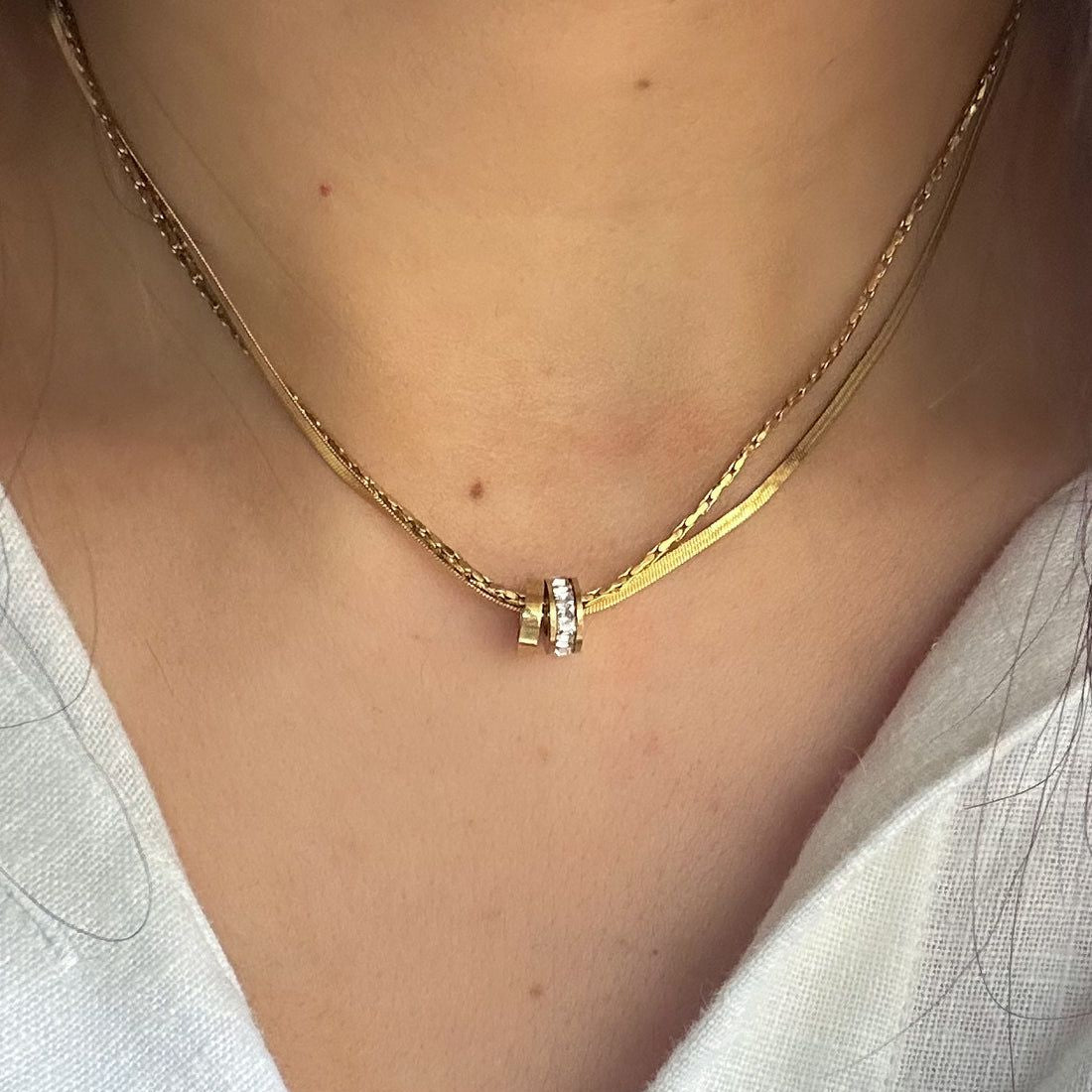 gold plated multilayered necklaces with a wheel shaped pendant studded with stones in a girls neck