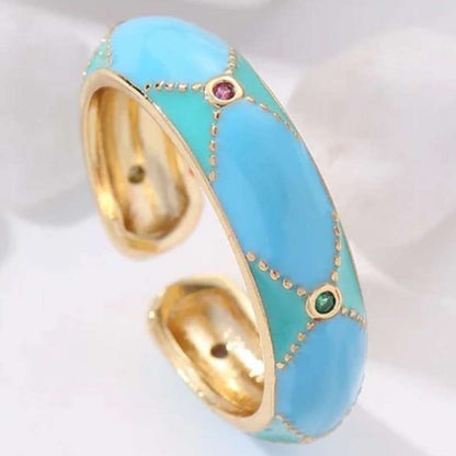 Turquoise ring with gold accents and gemstones on a white background