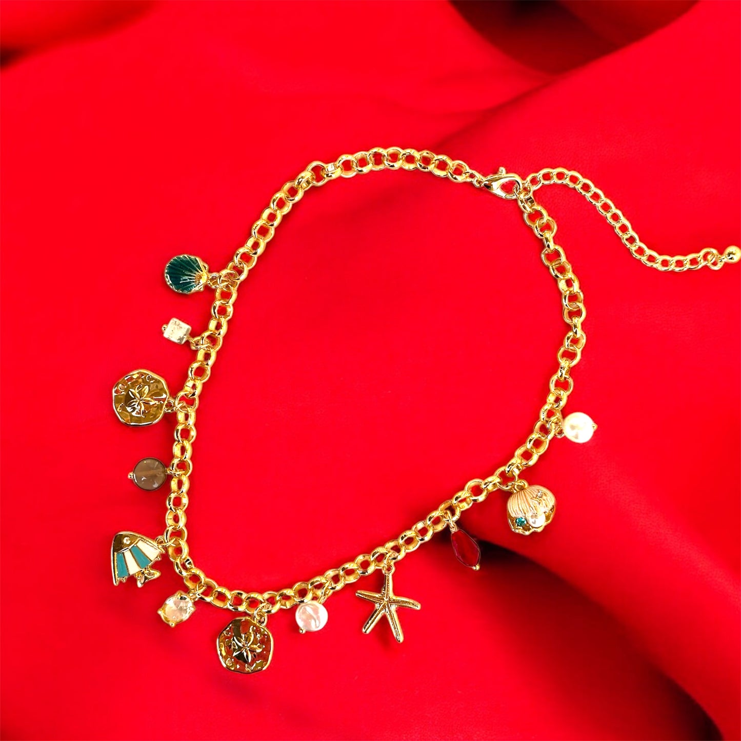 An 18K gold plated charm necklace with various charms including coins and pendants displayed on a mannequin.