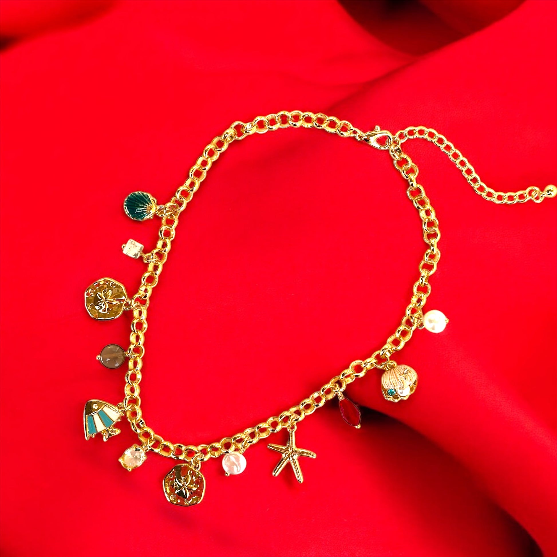 An 18K gold plated charm necklace with various charms including coins and pendants displayed on a mannequin.