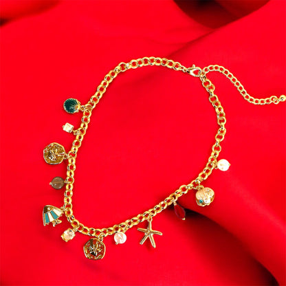 An 18K gold plated charm necklace with various charms including coins and pendants displayed on a mannequin.