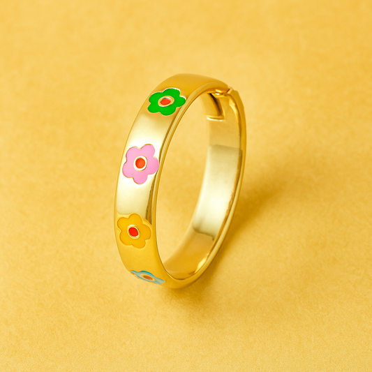 Gold ring with colorful flower designs on a yellow background