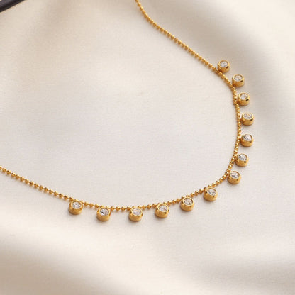 Gold necklace with small diamonds on a beige background