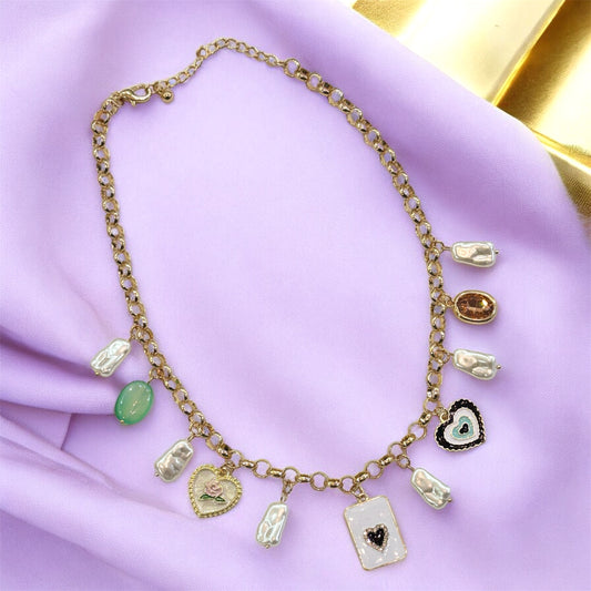 An 18K gold plated charm necklace with various charms including coins and pendants displayed on a mannequin.