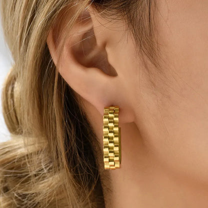 18k gold plated earrings with criss cross  pattern on them diplayed on a model ear