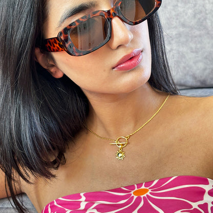 Minimalist gold plated necklace with sun charm pendant displayed on a model