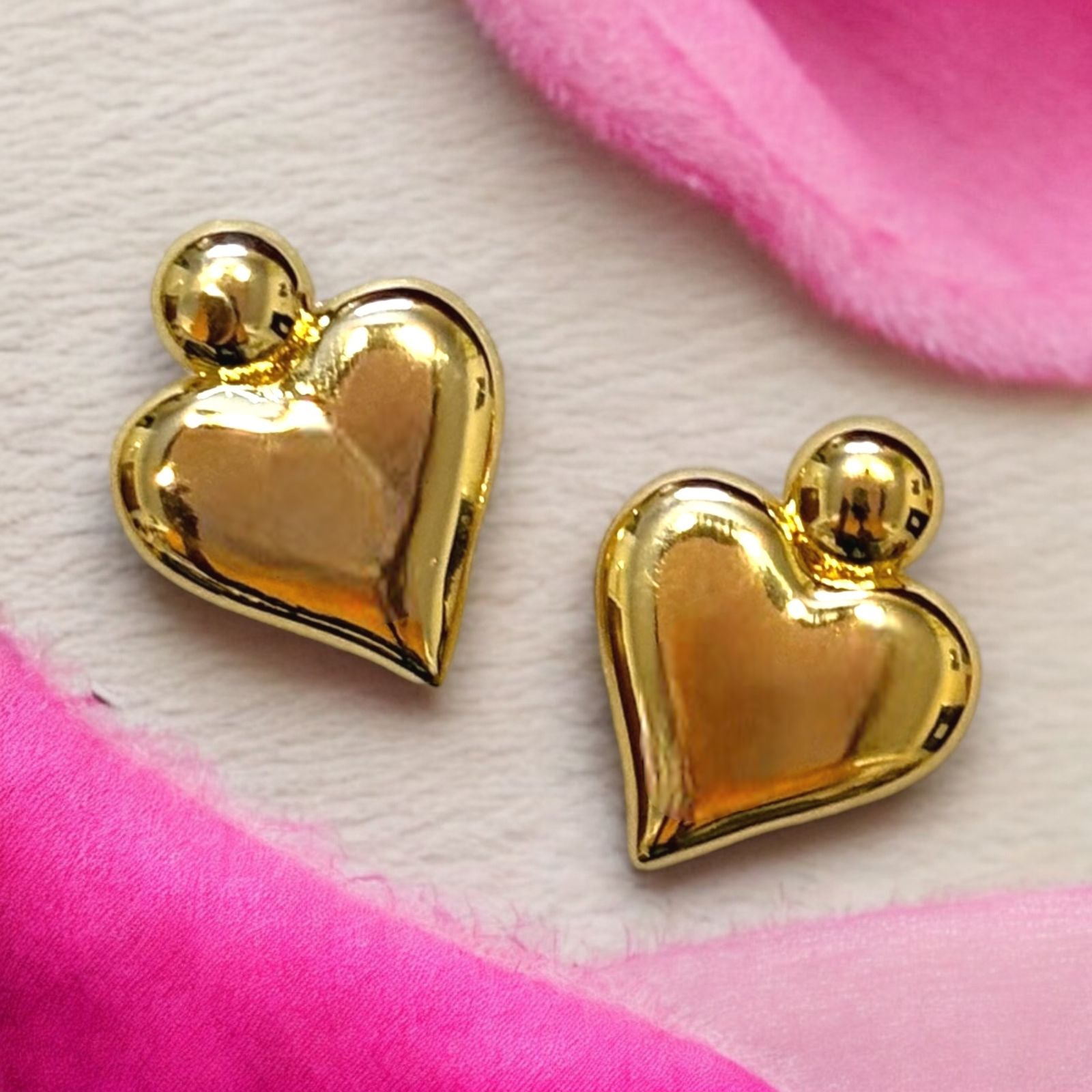 A pair of 18K gold plated heart-shaped earrings displayed against a white background