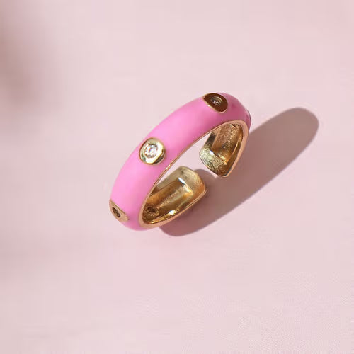 Pink ring with gold accents on a pink background