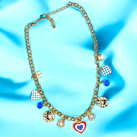An 18K gold plated charm necklace with  various charms including coins and pendants displayed on a mannequin.