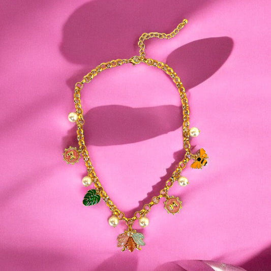 An 18K gold plated charm necklace with various charms including coins and pendants displayed on a mannequin.